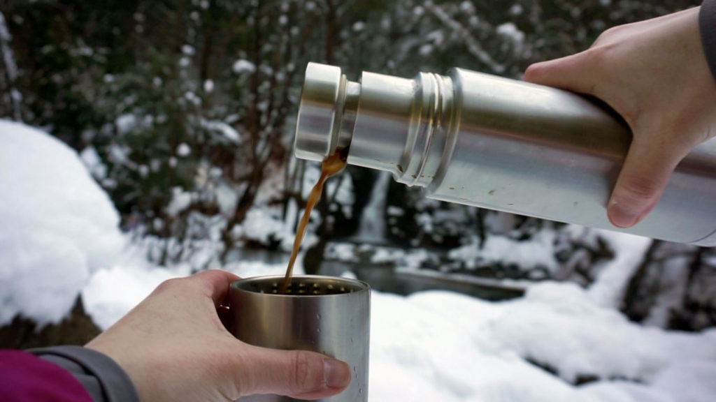 pouring a hot drink on a winter hike