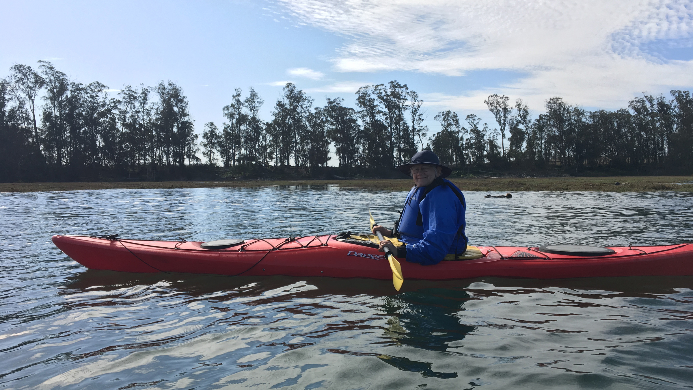 woman kayaking with an otter